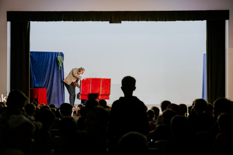 Aktor na scenie, widać także dużą publiczność dzieci